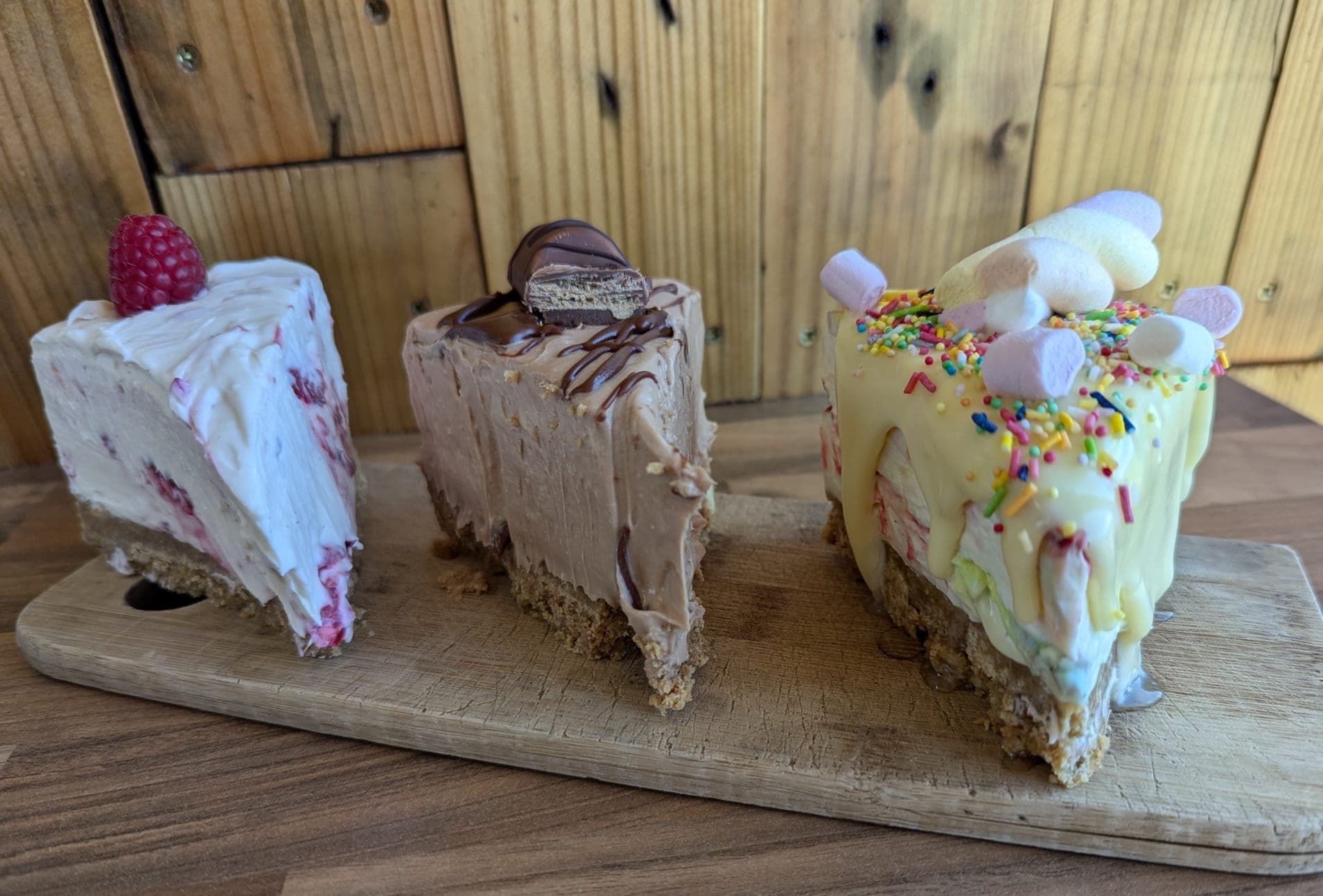 Three no-bake cheesecake slices — raspberry, Kinder chocolate, and party sprinkles