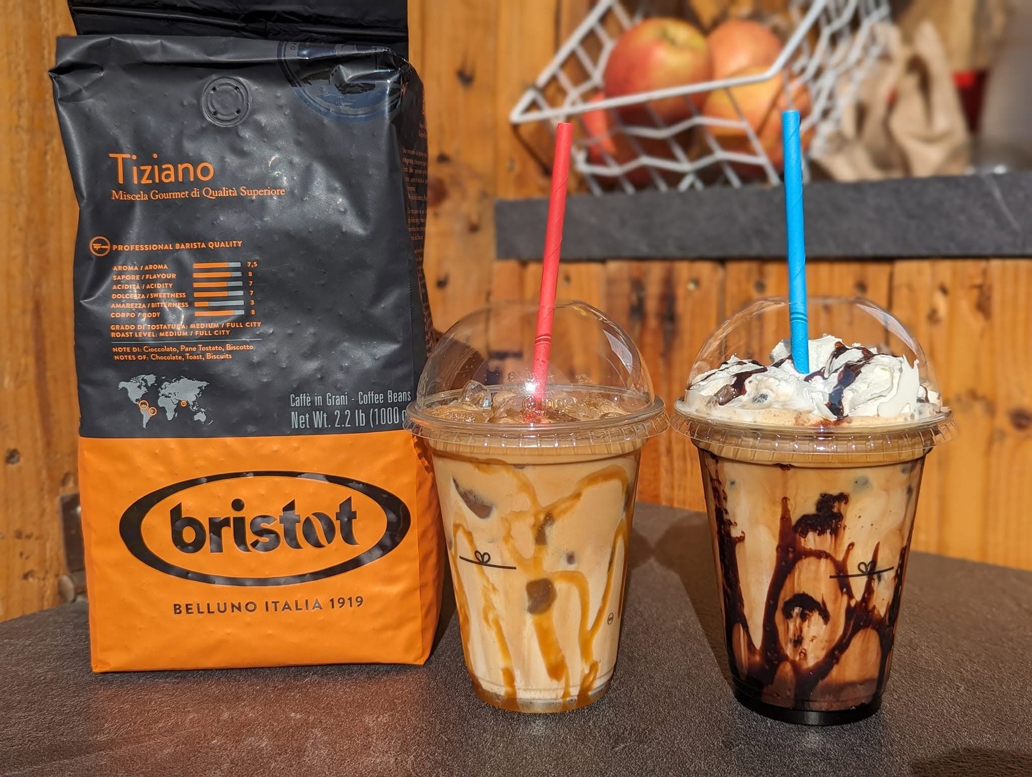 Bristot Italian coffee beans beside two iced coffees with caramel and chocolate