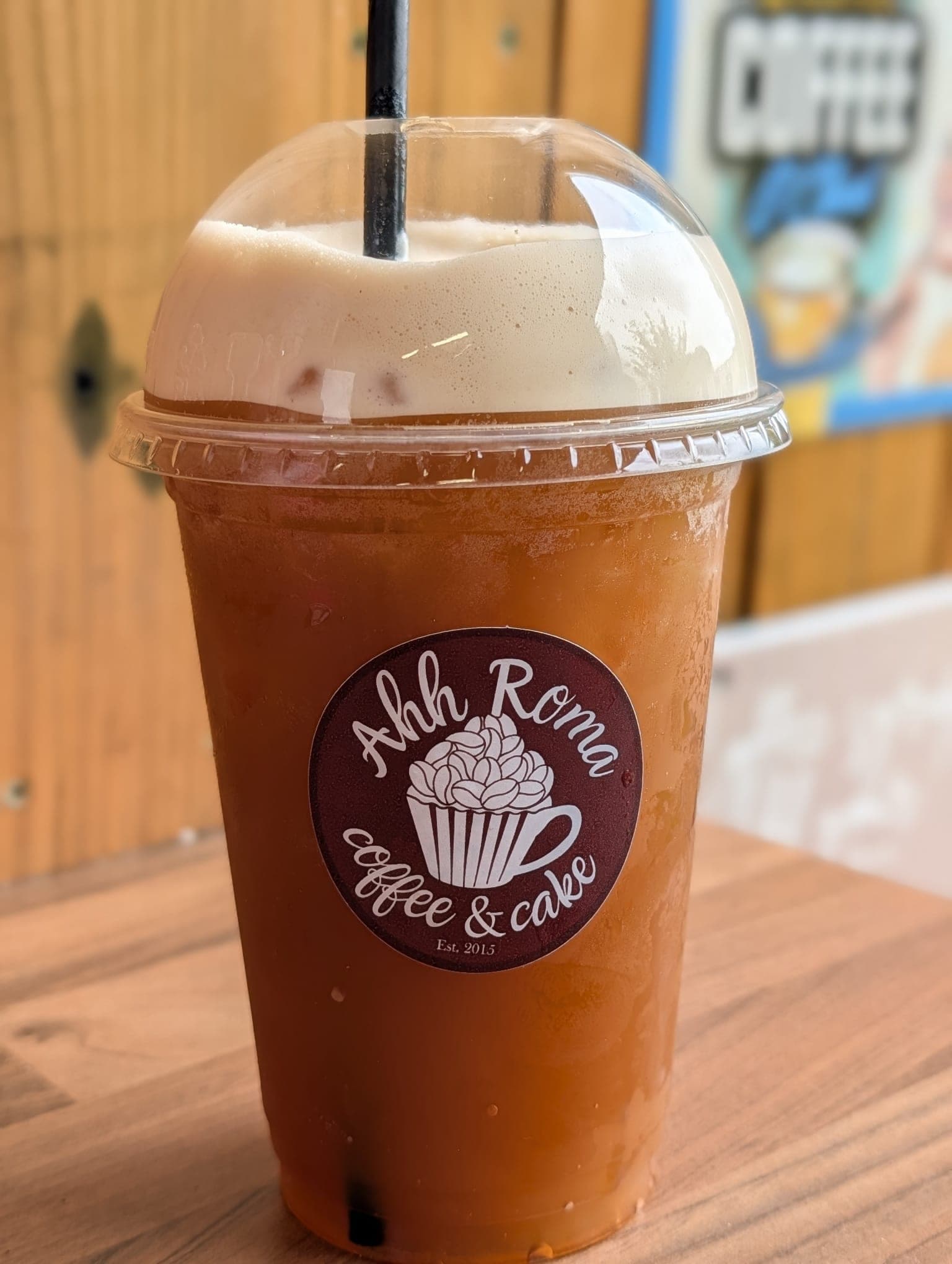 Iced coffee in a dome-lid cup with Ahh Roma branded sticker